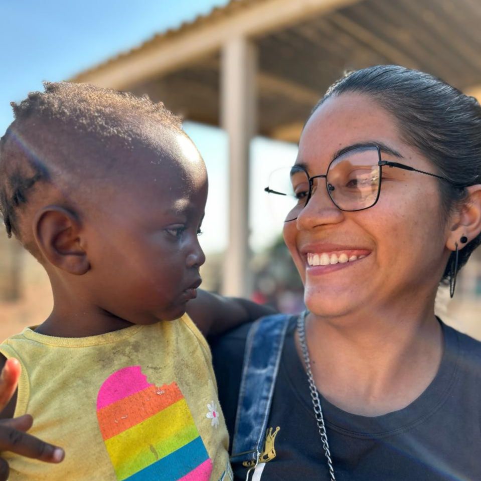 Letícia no colo com uma criança africana