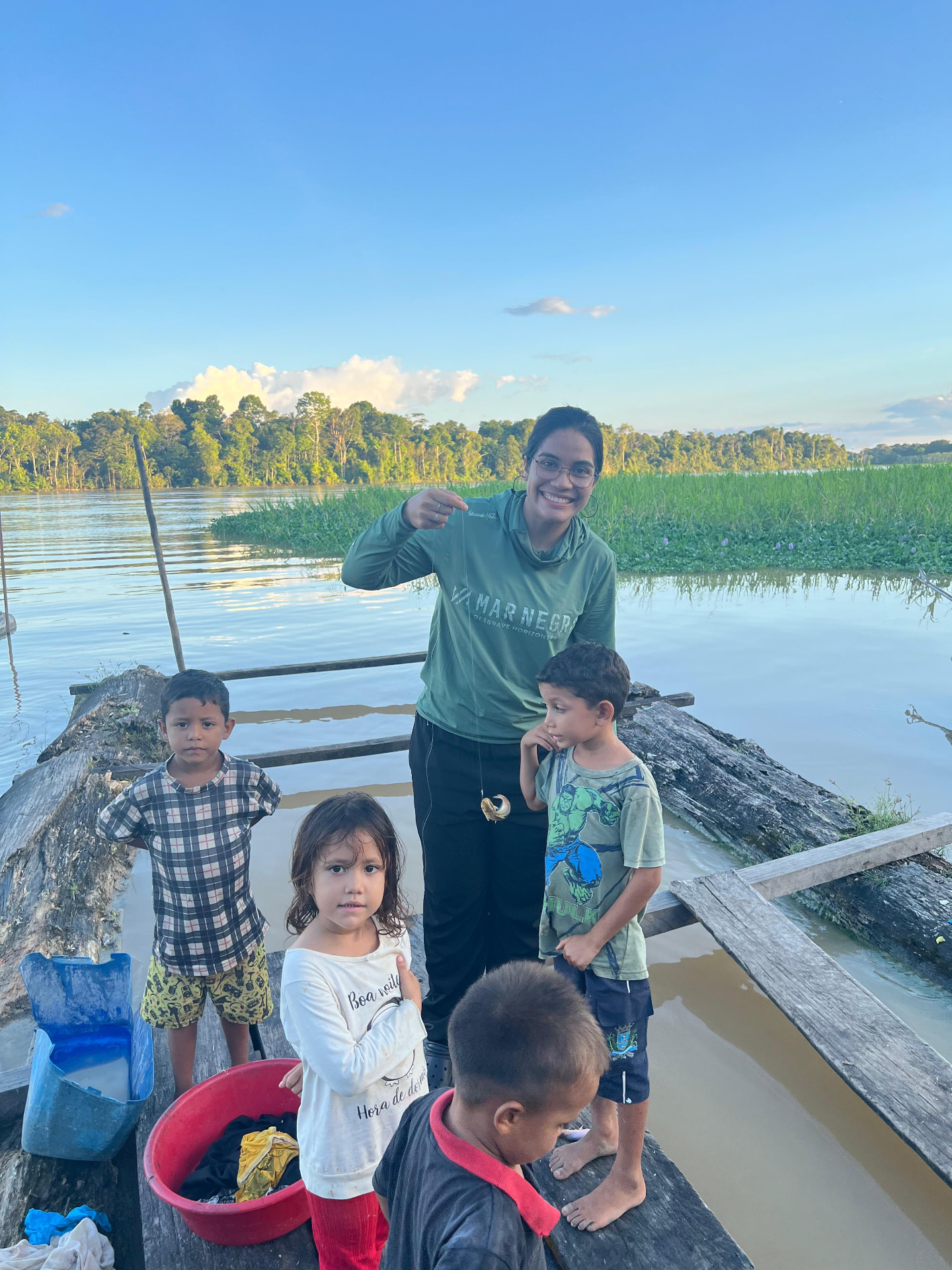 Letícia com crianças ribeirinhas em um trapiche na Amazônia